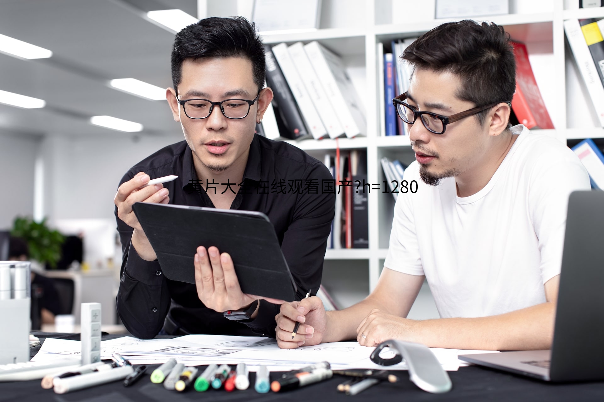 Two staff members are discussing designs, holding an ipad.